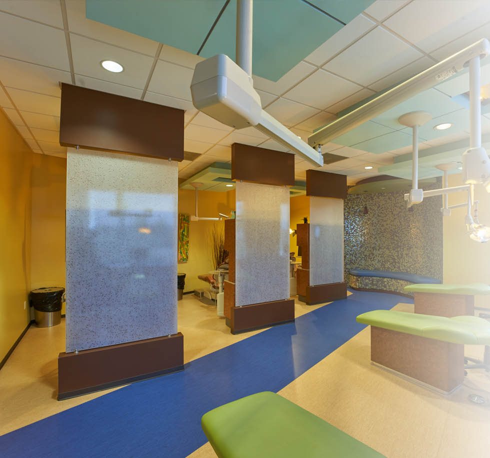 Bright hallway with a water wall and play area at Memorial Pediatric Dentistry